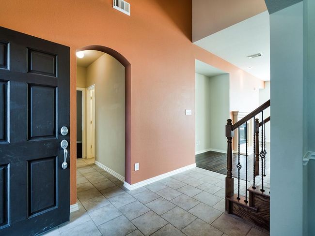 Entrance foyer with arched walkways, tile patterned flooring, baseboards, and stairway | Image 4