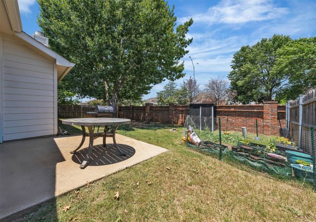 Fenced backyard with a patio area and storage closet | Image 18