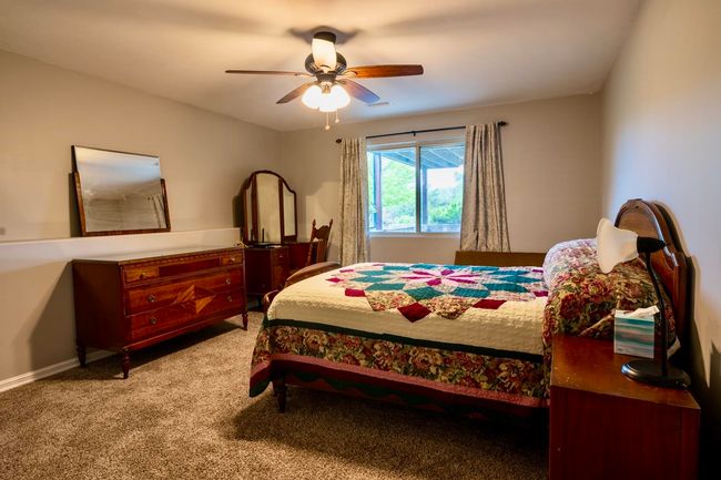 Bedroom with baseboards, a ceiling fan, and light colored carpet | Image 28