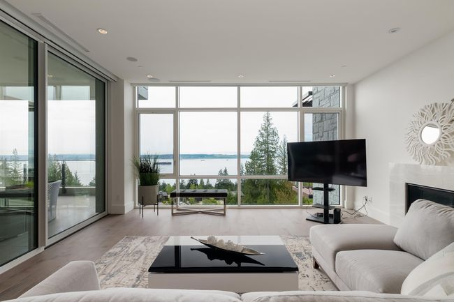 Living area featuring floor to ceiling windows, wood finished floors, a premium fireplace, and recessed lighting | Image 8
