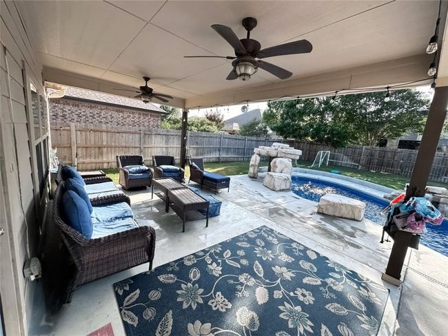 Fenced backyard featuring an outdoor living space, a patio, pool, and a ceiling fan | Image 28