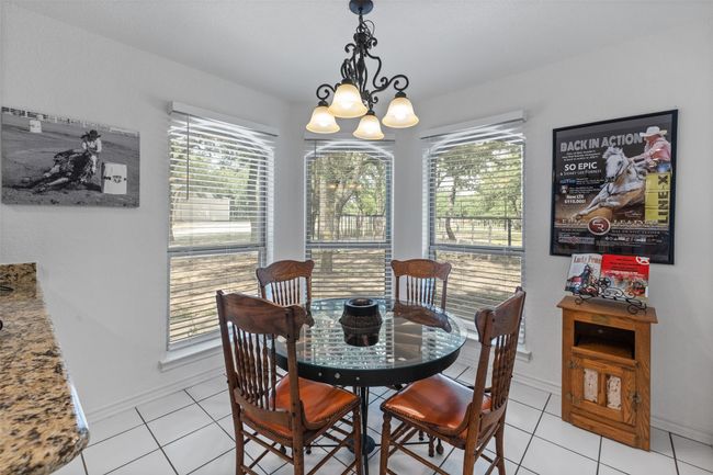 Dining area with an inviting chandelier, baseboards, and light tile patterned floors | Image 11