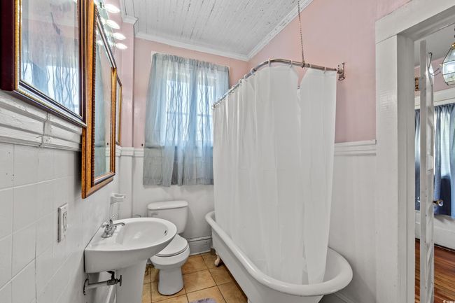 Full bathroom with crown molding, tile patterned floors, and shower / tub combo | Image 15