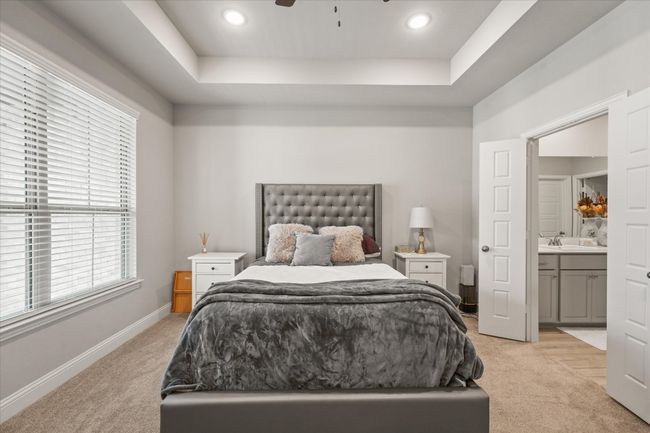 Bedroom with light carpet, a raised ceiling, ensuite bathroom, a ceiling fan, and recessed lighting | Image 23