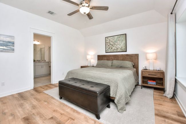 Bedroom featuring visible vents, baseboards, light wood finished floors, and lofted ceiling | Image 26