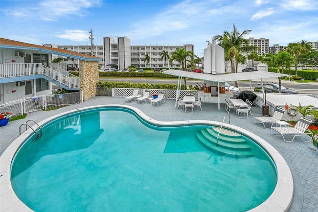 Take in the Florida Sun Relaxing or Entertaining Poolside. Community includes Heated Pool, Covered Cabana Area with BBQ, Lots of Pool Lounge Chairs & Seating, Surrounded by Lush Landscape, Plants & Flowers! | Image 21