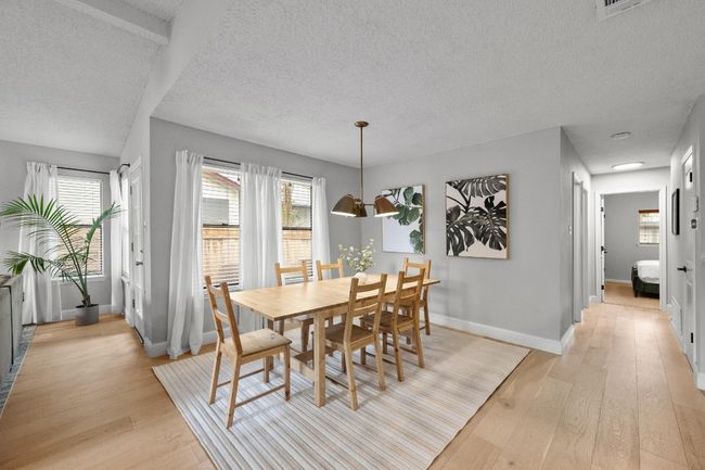 Dining space with ample windows and light engineered wood floors | Image 7
