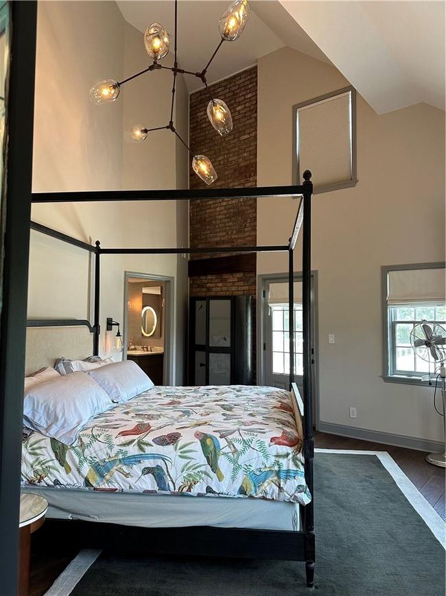 Bedroom featuring brick wall and high vaulted ceiling | Image 21