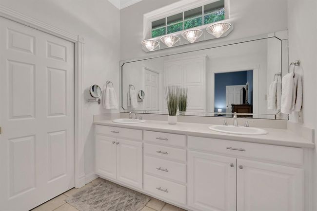 Bright lighting and double vanities in primary bathroom | Image 32