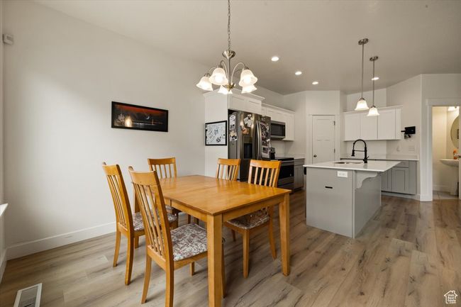 Dining area with recessed lighting, visible vents, light wood-type flooring, baseboards, and a chandelier | Image 20