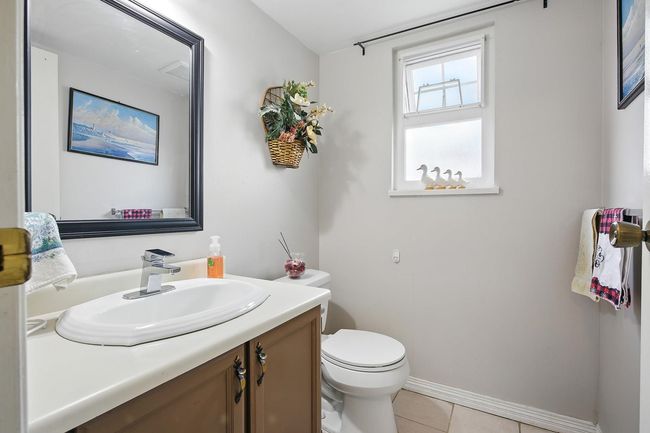 Half bath with toilet, vanity, tile patterned flooring, and baseboards | Image 17