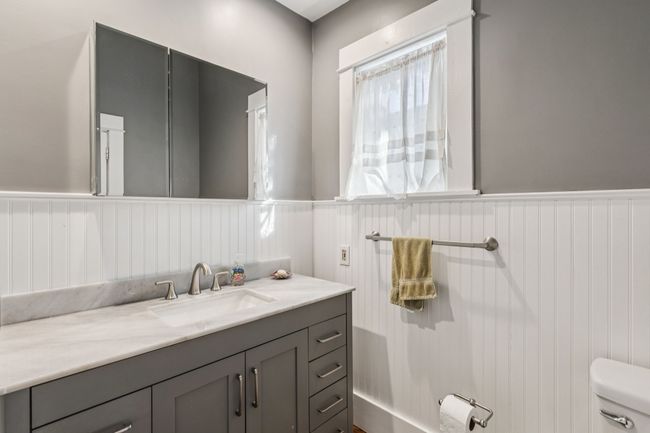 Bathroom with vanity, toilet, and a wainscoted wall | Image 12