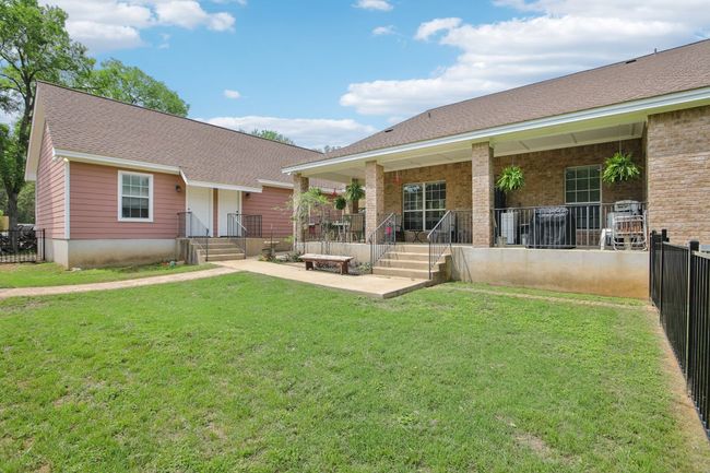 Back of house featuring roof with shingles, fence, brick siding, a lawn, and a porch | Image 23