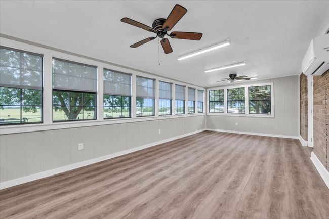 Unfurnished sunroom featuring a wall unit AC and wood finished floors | Image 15