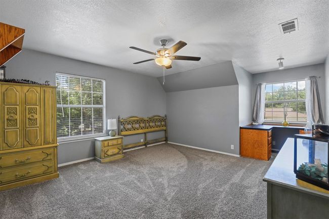 Office area featuring a textured ceiling, lofted ceiling, carpet floors, and ceiling fan | Image 27