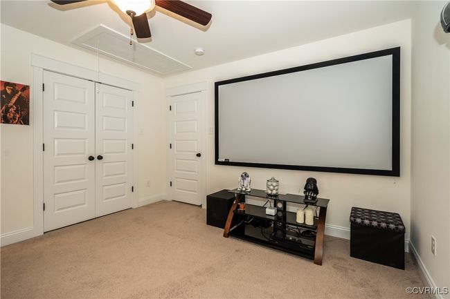 Carpeted cinema room featuring baseboards and ceiling fan | Image 26