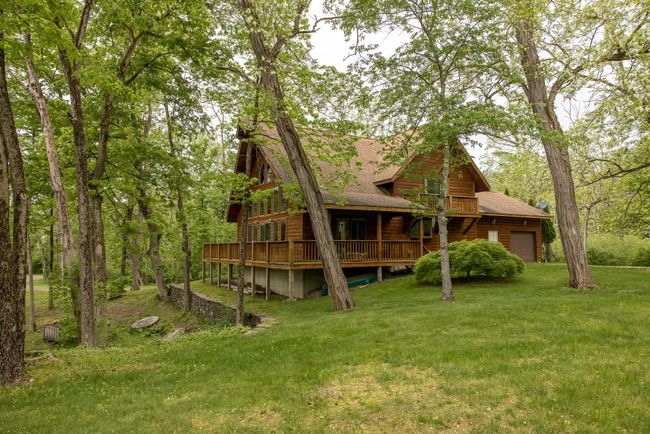 Rear view of house with a lawn, roof with shingles, a garage, and a wooden deck | Image 34