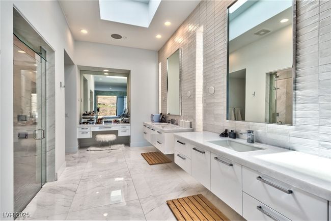 Bathroom featuring a skylight, tasteful backsplash, a sink, and a stall shower | Image 16