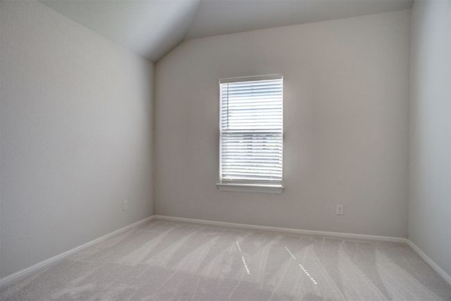 Empty room featuring light carpet, vaulted ceiling, and baseboards | Image 25