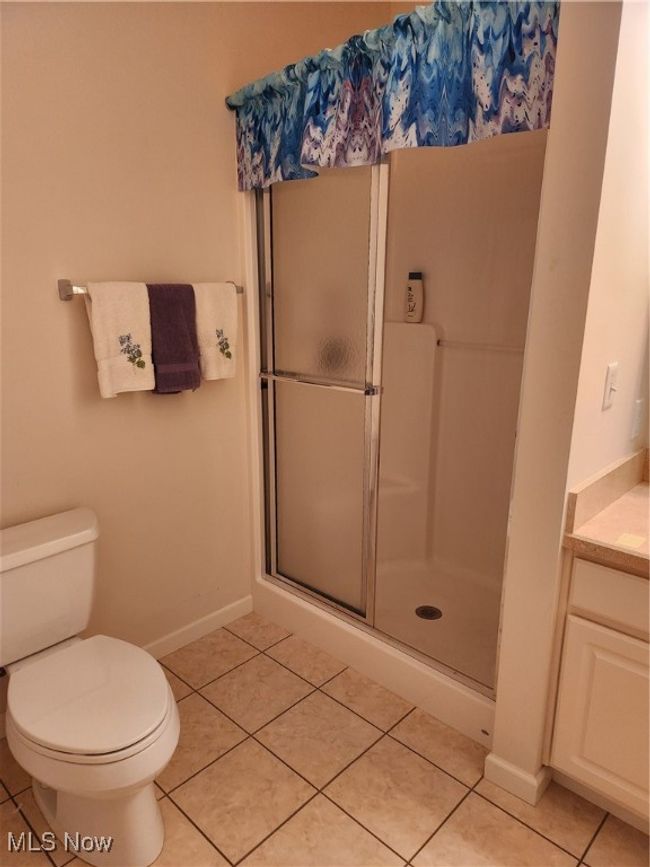 Back Bedroom's full bathroom featuring a stall shower, tile patterned floors, and vanity | Image 33