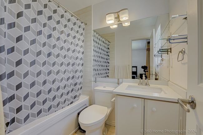 Bathroom featuring toilet, shower / bath combination with curtain, and vanity | Image 12