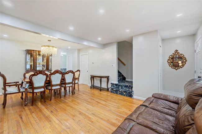 Living room featuring stairway, a notable chandelier, light wood-style floors, and recessed lighting | Image 8