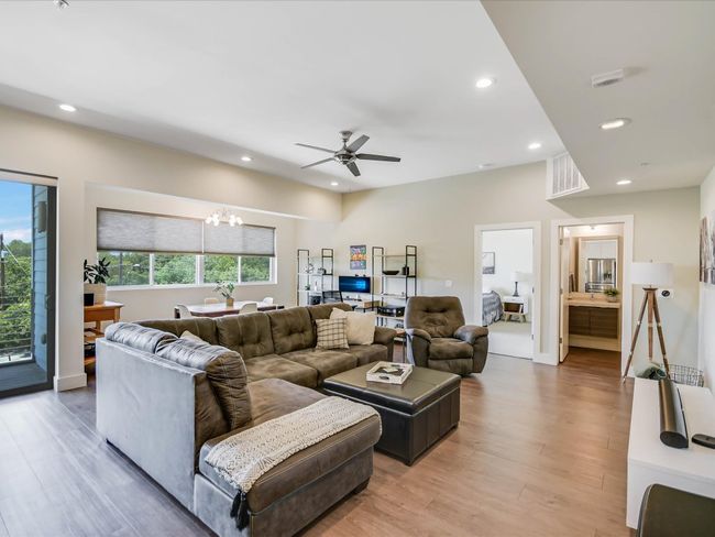 Living area featuring a chandelier, recessed lighting, light wood-type flooring, and a ceiling fan | Image 6