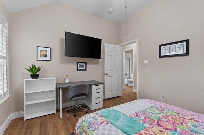 Bedroom with wood finished floors, lofted ceiling, and baseboards | Image 24