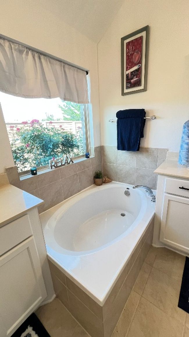 Bathroom with a bath, vanity, and tile patterned flooring | Image 22