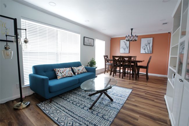 Living area featuring a chandelier, ornamental molding, and wood finished floors | Image 5