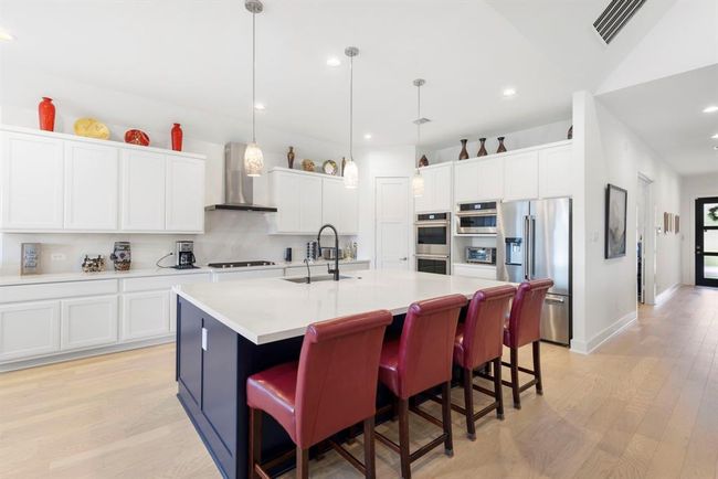 Elegant stainless steel double oven with dedicated microwave and appliance storage. | Image 18
