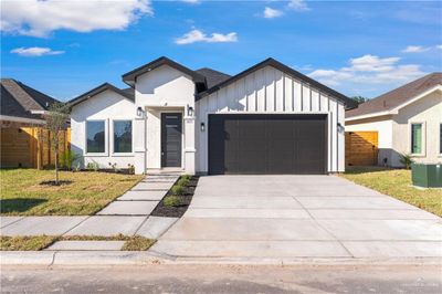 Modern inspired farmhouse featuring central AC, a front yard, and a garage | Image 1