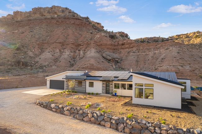 Exterior space with roof mounted solar panels, metal roof, stucco siding, and driveway | Image 53