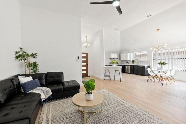Living room featuring high vaulted ceiling, ceiling fan with notable chandelier | Image 7