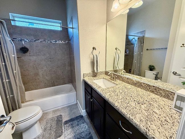 Full bathroom featuring toilet, vanity, and shower / bath combination with curtain | Image 21