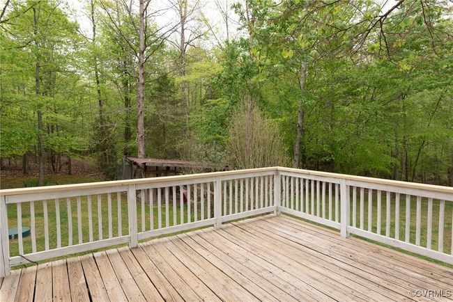 Large wooden deck with beautiful view of wooded back and detached pool area | Image 8