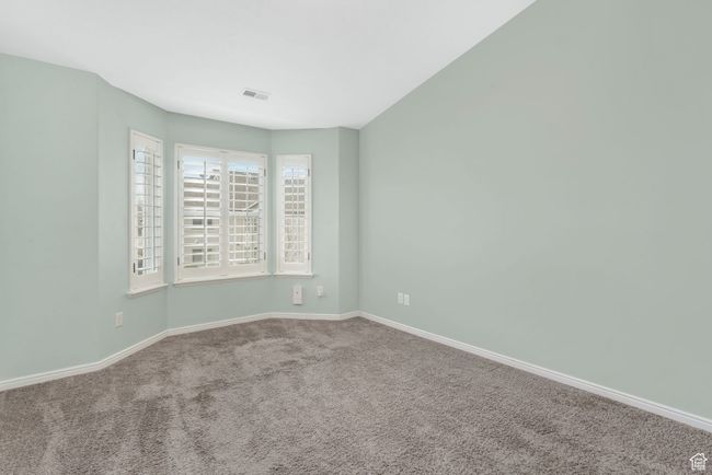 Carpeted spare room with baseboards and visible vents | Image 13