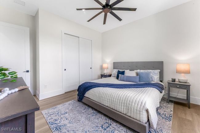 Bedroom with light wood finished floors, a closet, and a ceiling fan | Image 19