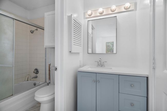 Bathroom featuring vanity and combined bath / shower with glass door | Image 14