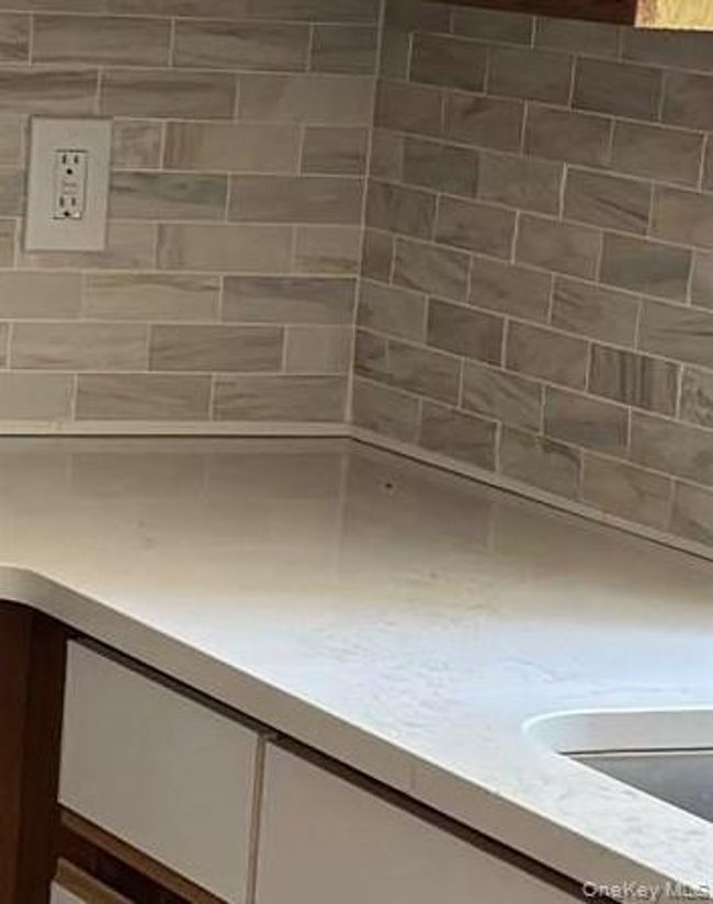 Kitchen view of light countertops and white cabinetry | Image 7