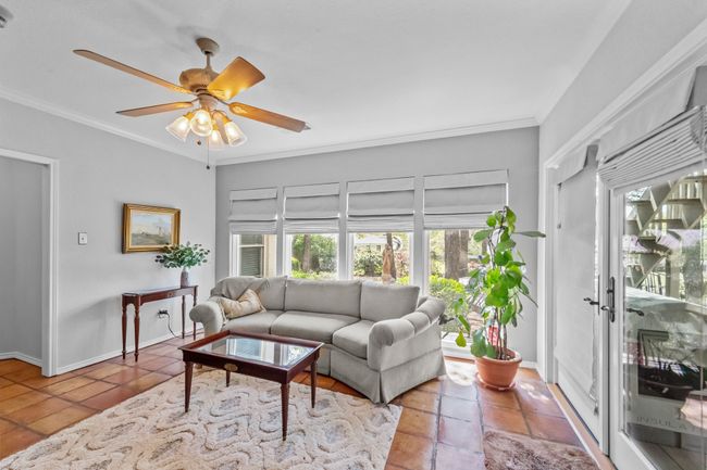 Tiled living area featuring baseboards, crown molding, and a ceiling fan | Image 11
