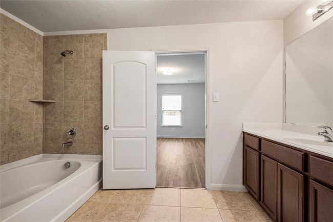 Bathroom with vanity, shower combination, tile patterned floors, and baseboards | Image 14