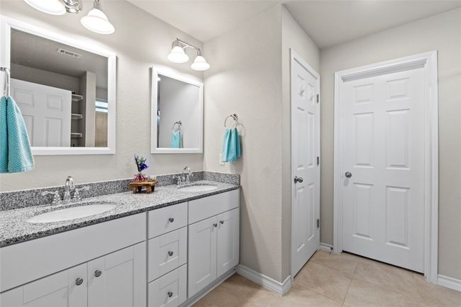 Primary bathroom featuring double sink vanity, large walk-in closet | Image 21