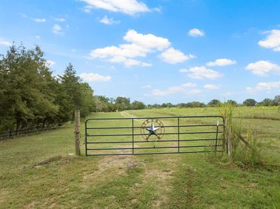 View of gate featuring a lawn and a rural view | Image 1