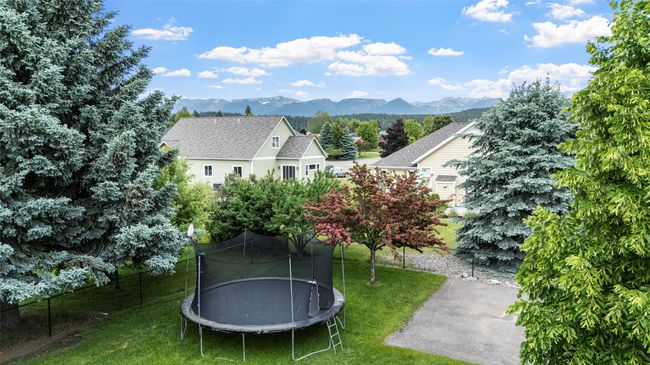 View of grassy yard featuring a trampoline and a mountain view | Image 20