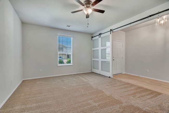Game room or Office featuring a barn door, a ceiling fan, and carpet | Image 5