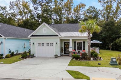 Craftsman house with a front lawn, covered porch, and a garage | Image 1