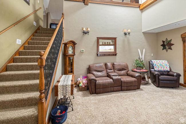 Carpeted living room with a towering ceiling | Image 7