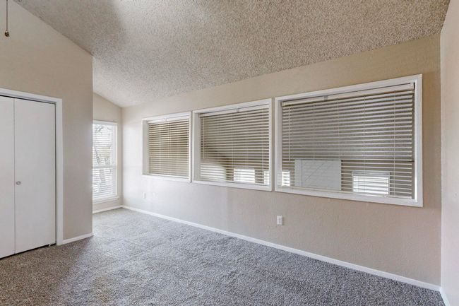 Unfurnished bedroom featuring baseboards, lofted ceiling, a textured ceiling, and carpet floors | Image 27