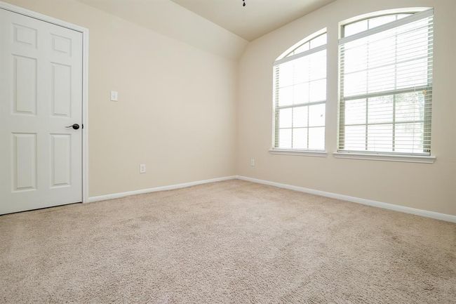 Double arched windows bring morning sunshine and deep night skies into this generous secondary bedroom; any of which may serve as a nursery, hobby room, work out space? It's all up to you. | Image 22